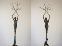 Phoenix Rising  Growing from a found tree root Phoenix Rising-2mounted on a piece of sandstone, Phoenix Rising is one of the tallest sculptures I have so far produced. The root has been altered by the addition of small female figures made from epoxy, and patinaed in blue to give the suggestion of water. The figures wind around the sculpture in a clockwise direction until a more recognizable larger human representation is formed continuing with arms held aloft then terminating in tree branches, giving the impression of both growth and rebirth.  The figure has two distinct aspects, the female looking straight ahead at the world, and the male with his head facing upwards towards the sun and the future. 54 x 12 x 6 inches   $3250.00